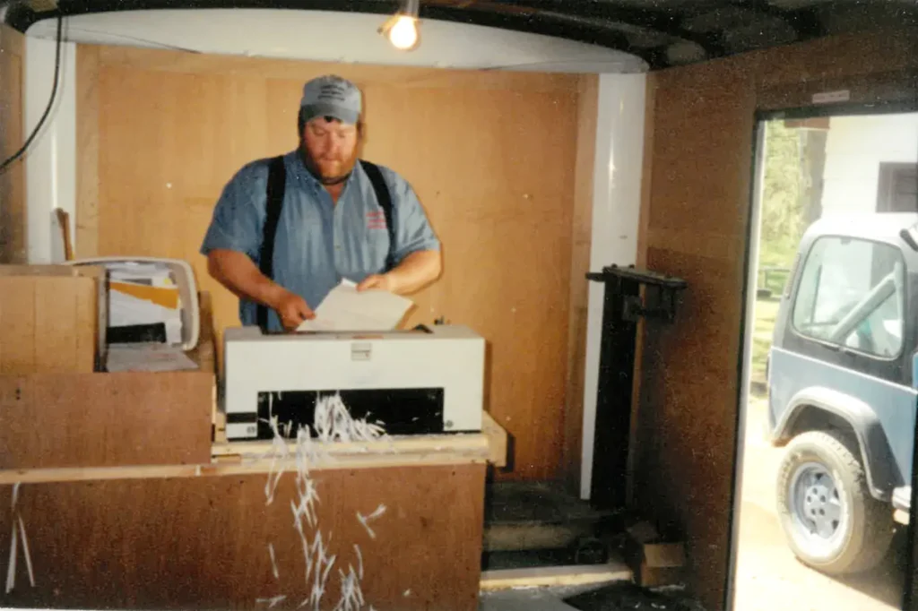 Historical photo of Country Mile Document Destruction owner shredding paper inside his traveling shredder truck - 2