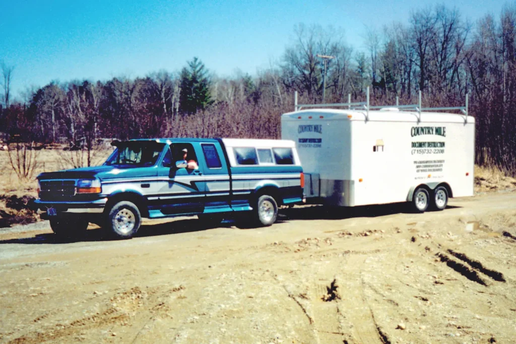 Historical photo of Country Mile Document Destruction owner driving a truck towing his mobile paper shredder trailer